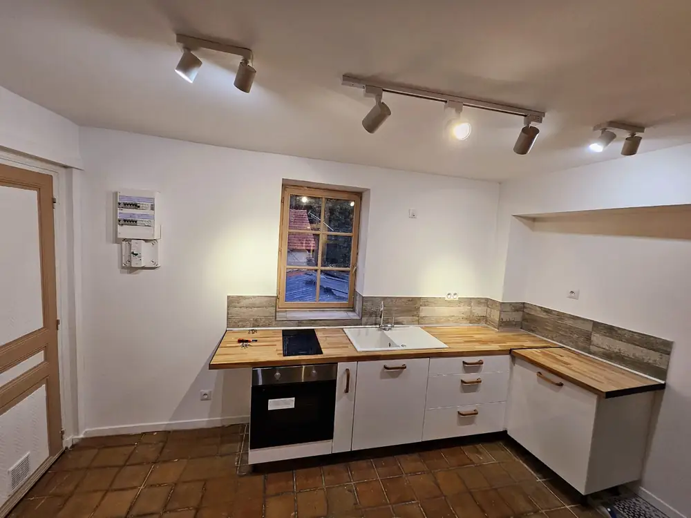 Cuisine équipée — Plan de travail bois, crédence et rails de spots.