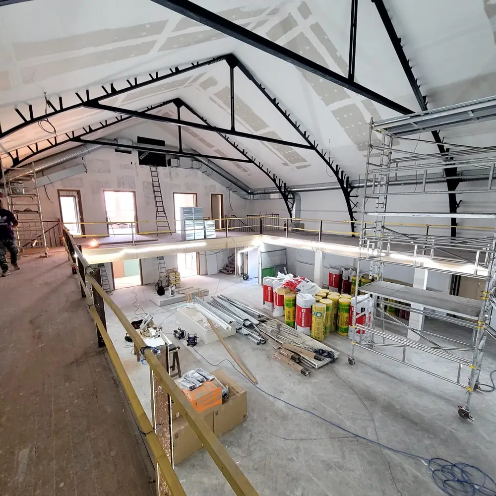 Salle des fêtes en travaux — Échafaudages, isolation et cloisons en cours.